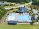 Aerial view of neighborhood pool with sun shelters, clubhouse, green spaces and a splash pad in a residential community at 1840 Flint Valley Ln, Apex, NC 27502