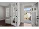 Light-filled foyer with hardwood floors and view to a cozy sitting room through glass paneled door at 1840 Flint Valley Ln, Apex, NC 27502
