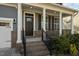 Inviting front porch with brick base columns and black metal railings leading to the front door at 1840 Flint Valley Ln, Apex, NC 27502