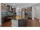 Modern kitchen featuring a large island with granite countertops, stainless steel appliances, and dark wood cabinets at 1840 Flint Valley Ln, Apex, NC 27502