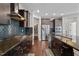 Gourmet kitchen with dark wood cabinets, granite countertops, stainless steel appliances, and tiled backsplash at 1840 Flint Valley Ln, Apex, NC 27502