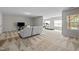 A large, carpeted living room with a sofa, TV, and exercise equipment near bright windows at 1840 Flint Valley Ln, Apex, NC 27502
