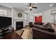 Spacious living room with a fireplace, large brown sectional sofa, and an adjacent dining area with a red accent wall at 1840 Flint Valley Ln, Apex, NC 27502