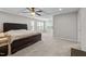 Bright main bedroom with a decorative tray ceiling, ceiling fan, large bed, and lots of windows offering natural light at 1840 Flint Valley Ln, Apex, NC 27502