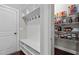 A mudroom with a built-in bench, coat hooks, and a pantry with shelving for organized storage at 1840 Flint Valley Ln, Apex, NC 27502