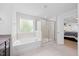 Bathroom featuring a soaking tub, glass shower, and view of the bedroom at 190 Bingham Creek Dr, Garner, NC 27529