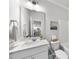 Bright bathroom with a white vanity, a large mirror, and a glimpse into the kitchen at 20 Carolina Maple Dr, Franklinton, NC 27525