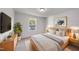 This neutral bedroom features a wooden bed frame, large window, and mounted TV at 20 Carolina Maple Dr, Franklinton, NC 27525