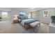 Comfortable bedroom with a blue bedspread, bench, and two large windows at 20 Carolina Maple Dr, Franklinton, NC 27525