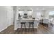 Stylish kitchen featuring white cabinets, stainless steel appliances, an island with stool seating, and adjacent dining area at 20 Carolina Maple Dr, Franklinton, NC 27525