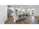 Modern kitchen featuring white cabinets, stainless steel appliances, an island with stool seating, and adjacent dining area at 20 Carolina Maple Dr, Franklinton, NC 27525