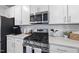 Close up of kitchen featuring stainless steel appliances, gas range, white cabinets, backsplash and a light quartz countertop at 20 Carolina Maple Dr, Franklinton, NC 27525