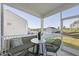Relaxing screened porch with wicker furniture, a table, and views of the backyard and neighboring homes at 20 Carolina Maple Dr, Franklinton, NC 27525