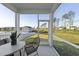 Comfortable screened porch featuring wicker furniture, a table, and scenic views of the surrounding landscape at 20 Carolina Maple Dr, Franklinton, NC 27525