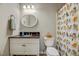 Bright bathroom with tiled shower curtain, white vanity, and rounded mirror at 201 Dunhagan Pl, Cary, NC 27511