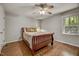 Comfortable bedroom with a ceiling fan, window views, and hardwood floors at 201 Dunhagan Pl, Cary, NC 27511
