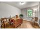 Cozy bedroom with wooden desk and chairs, bright window overlooking trees, and plank flooring at 201 Dunhagan Pl, Cary, NC 27511