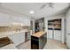 Bright kitchen featuring white cabinets, stainless steel appliances, and an adjacent laundry closet at 201 Dunhagan Pl, Cary, NC 27511