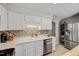 Cozy kitchen with white cabinets, mosaic backsplash, stainless steel dishwasher, and a stainless steel refrigerator at 201 Dunhagan Pl, Cary, NC 27511