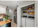 Laundry closet with shelving, a washer, and dryer adjacent to the stainless steel refrigerator at 201 Dunhagan Pl, Cary, NC 27511