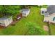 Aerial view of backyard with mature trees, outbuildings, and lush green grass at 2024 Country Trails Dr, Clayton, NC 27520