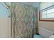 Bathroom with a patterned shower curtain, white tile, and updated fixtures at 2024 Country Trails Dr, Clayton, NC 27520