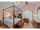 Spacious bedroom with a four-poster bed, wooden floors, and an arched window at 2024 Country Trails Dr, Clayton, NC 27520
