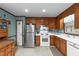 Well-lit kitchen with white appliances, traditional wood cabinets, and tiled floor at 2024 Country Trails Dr, Clayton, NC 27520