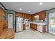 Functional kitchen with stainless steel refrigerator, white appliances and classic wood cabinetry at 2024 Country Trails Dr, Clayton, NC 27520