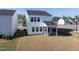 Backyard view of the two-story home, featuring a covered patio and well-maintained lawn at 205 Fig Tree Bnd, Zebulon, NC 27597