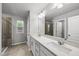 Bathroom featuring double sink vanity with modern fixtures and a tiled walk-in shower at 205 Fig Tree Bnd, Zebulon, NC 27597