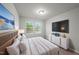 Bright bedroom with modern furniture, large bed, two windows, and a television at 205 Fig Tree Bnd, Zebulon, NC 27597