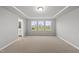 Expansive bedroom showcasing a tray ceiling, large windows, and backyard views at 205 Fig Tree Bnd, Zebulon, NC 27597