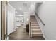 Bright foyer featuring hardwood floors, staircase, and views into the kitchen and living areas at 205 Fig Tree Bnd, Zebulon, NC 27597