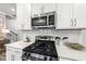 Modern kitchen features stainless steel appliances, white cabinets, and quartz countertops at 205 Fig Tree Bnd, Zebulon, NC 27597