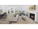 Bright living room featuring fireplace, hardwood floors, large windows, neutral colors, and modern furniture at 205 Fig Tree Bnd, Zebulon, NC 27597