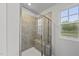 A tiled walk-in shower with glass door, built-in bench, and window at 205 Fig Tree Bnd, Zebulon, NC 27597