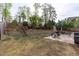 Spacious backyard boasts a stone retaining wall, mature trees, and a patio seating area for outdoor enjoyment at 2109 Hemlock Hill Dr, Durham, NC 27703