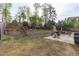 Spacious backyard boasts a stone retaining wall, mature trees, and a patio seating area for outdoor enjoyment at 2109 Hemlock Hill Dr, Durham, NC 27703