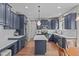 Modern kitchen with an island, stainless steel appliances, sleek cabinetry, and hardwood floors for culinary enthusiasts at 2109 Hemlock Hill Dr, Durham, NC 27703