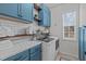 Well-organized laundry room with blue cabinets, marble countertops, and modern washer and dryer for efficient chores at 2109 Hemlock Hill Dr, Durham, NC 27703