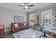 Bright office with large windows, a ceiling fan, and a comfortable leather couch at 2109 Hemlock Hill Dr, Durham, NC 27703