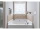 Large soaking tub with a decorative window offering natural light and style at 2113 Conroy Way, Willow Springs, NC 27592