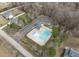 Aerial view of community pool with parking and playground surrounded by trees and residential houses at 2113 Conroy Way, Willow Springs, NC 27592