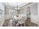 Elegant dining room with a tray ceiling, hardwood floors, a chandelier and wainscoting at 2113 Conroy Way, Willow Springs, NC 27592