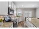 Well-lit kitchen featuring granite countertops, modern appliances, and wooden flooring at 2113 Conroy Way, Willow Springs, NC 27592