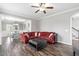 Comfortable living room featuring hardwood floors, a large red sectional, and an open dining area at 2113 Conroy Way, Willow Springs, NC 27592