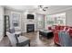 Cozy living room featuring a fireplace, ceiling fan, hardwood floors and large windows at 2113 Conroy Way, Willow Springs, NC 27592