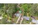 Aerial view showcases home with lush landscaping, a long driveway, and nearby homes in a wooded area at 2120 Hillock Dr, Raleigh, NC 27612