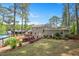 View of the home's backyard, showcasing a well-maintained lawn, mature trees, and landscaping at 2120 Hillock Dr, Raleigh, NC 27612